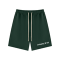 Green athletic shorts with a brand logo on a light gray background