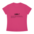 A bright pink short-sleeve crewneck t-shirt with black printed text on the chest reading '1 JOHN 1:7' followed by a Bible verse, shown on a plain white background.