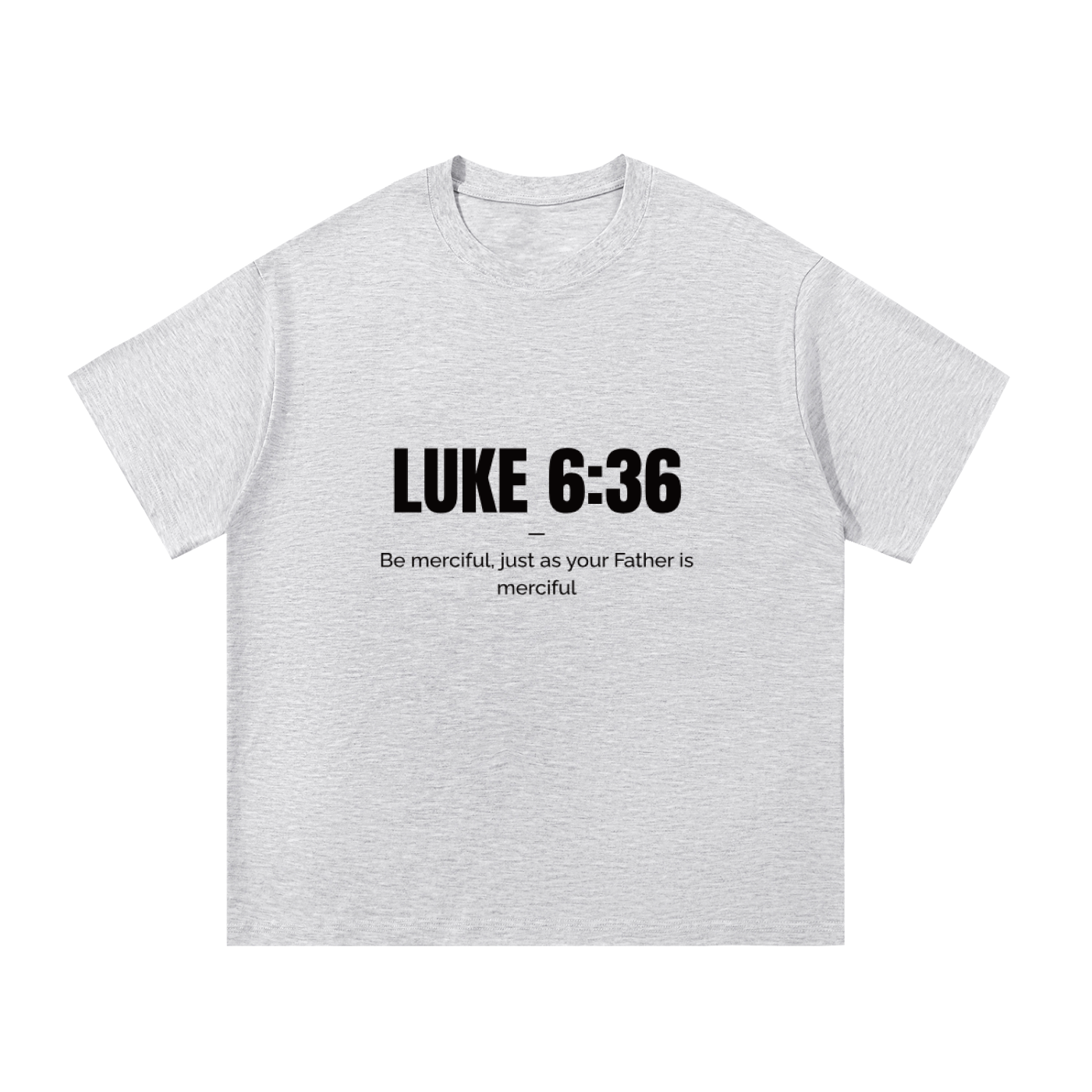 A light heather gray short-sleeve t-shirt with black printed text on the chest reading 'LUKE 6:36' and 'Be merciful, just as your Father is merciful'.